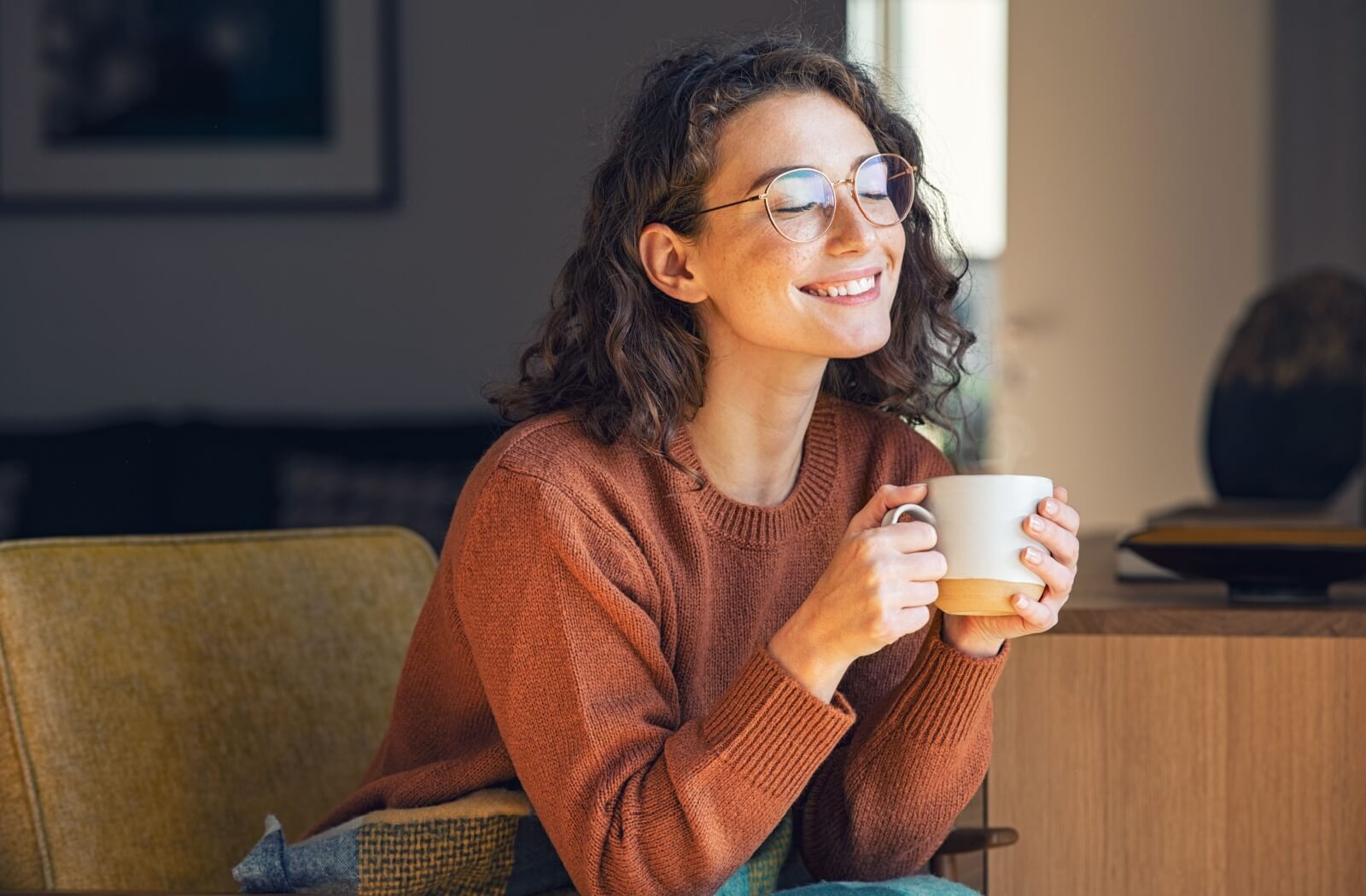 A person enjoys a cup of tea while also enjoying their healthy, white smile.