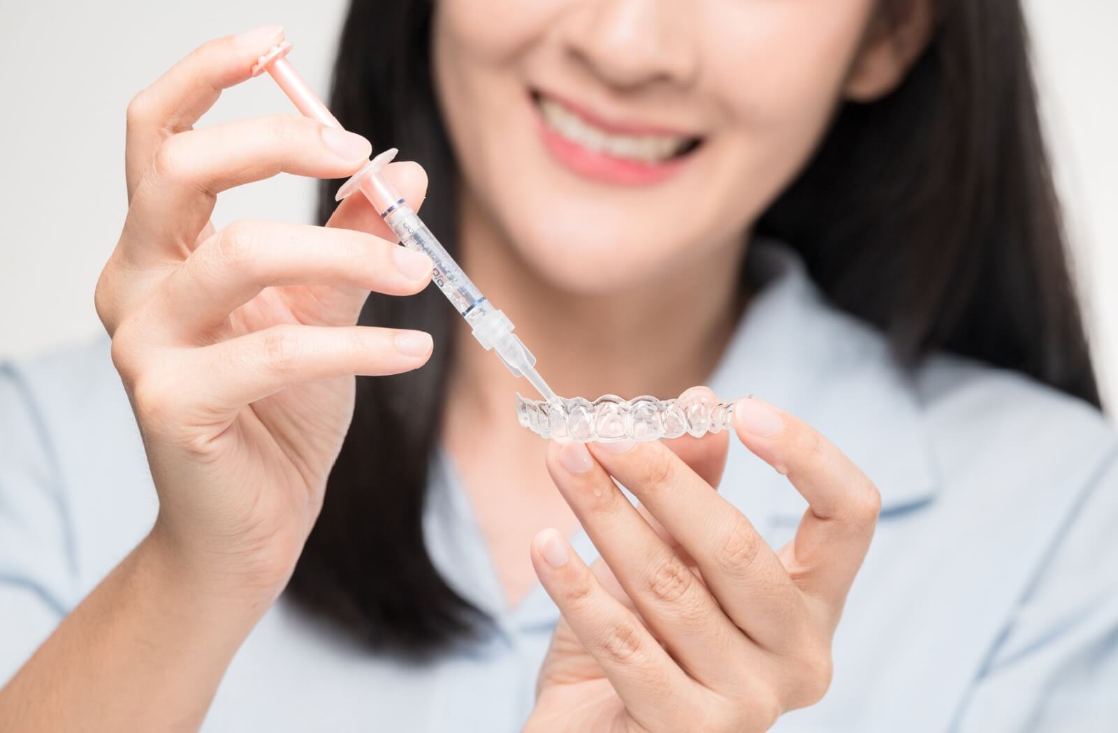 Whitening gel is being applied to a whitening tray before being used.